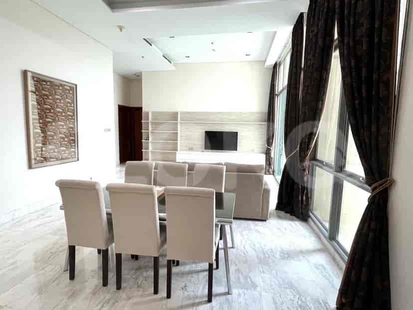 Dining area with glass-top table, eight chairs, and access to the kitchen.