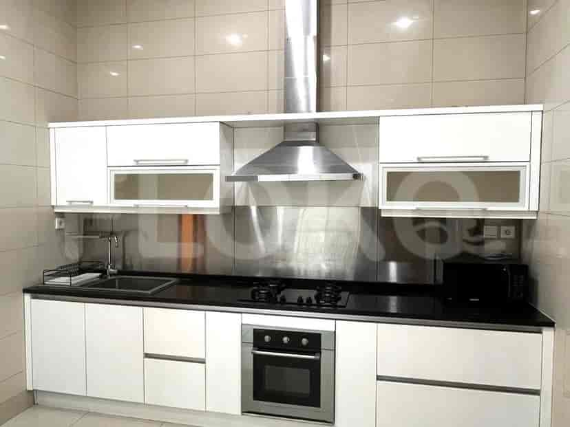 Kitchen with stainless steel appliances, black countertops, and white cabinetry.