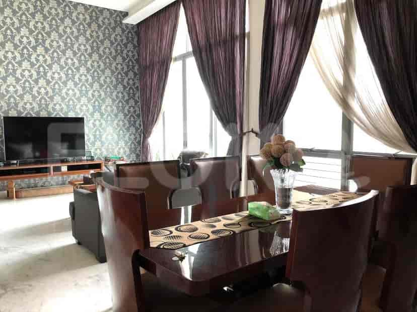 Dining room with large windows, dining table, and TV.