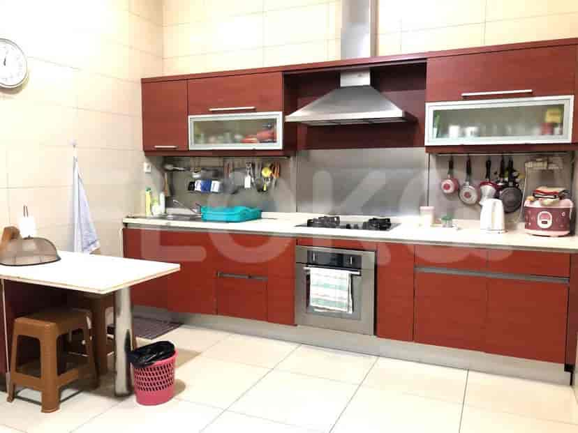 Kitchen with cabinetry, stove, and small table.