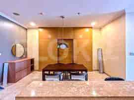 A dining room with a dining table and a round mirror.
