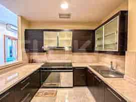 A modern kitchen with a U-shaped layout and dark wood cabinets.