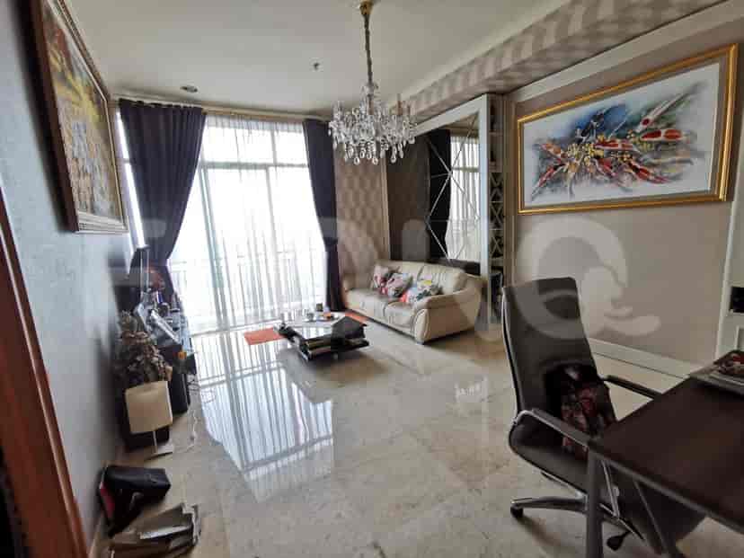 A luxury living room featuring a sofa, large windows, and a chandelier.