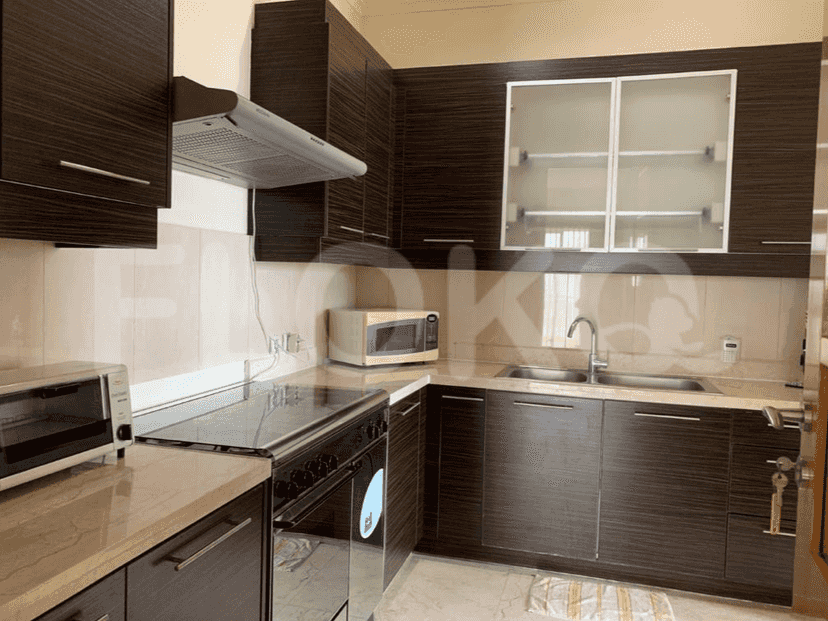 Modern kitchen with dark wooden cabinets, electric stove, and a microwave.