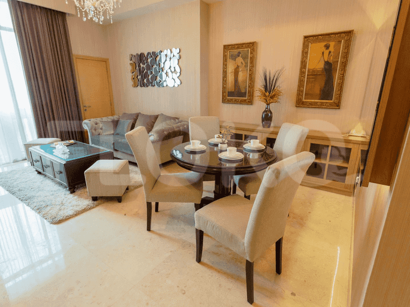 Elegant dining area with a round table, chairs, and a tufted sofa in a modern, well-lit space.