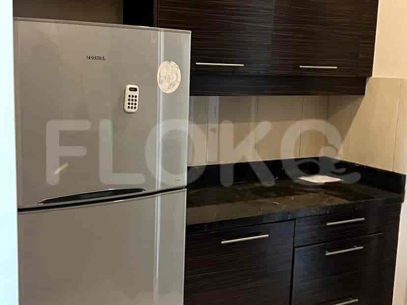 A small kitchen featuring a refrigerator, cabinets and counter.