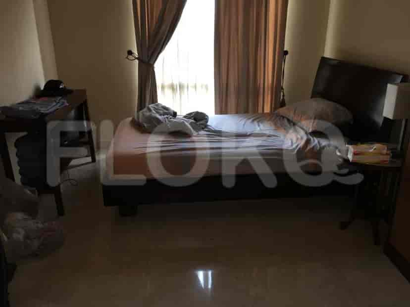 Kamar tidur dengan tempat tidur dan meja samping.