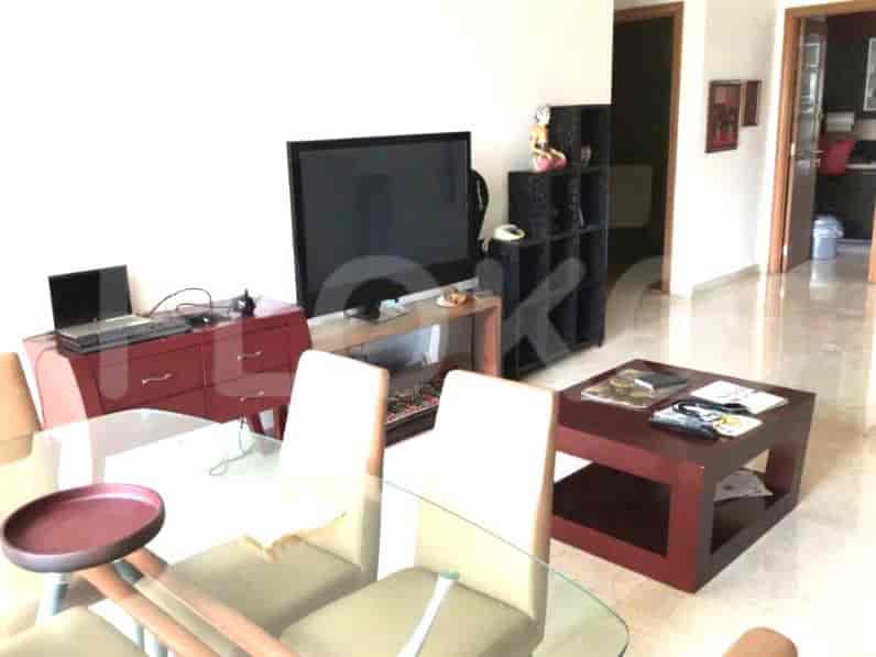 Living area showing entertainment center, dining space, and a decorative coffee table.