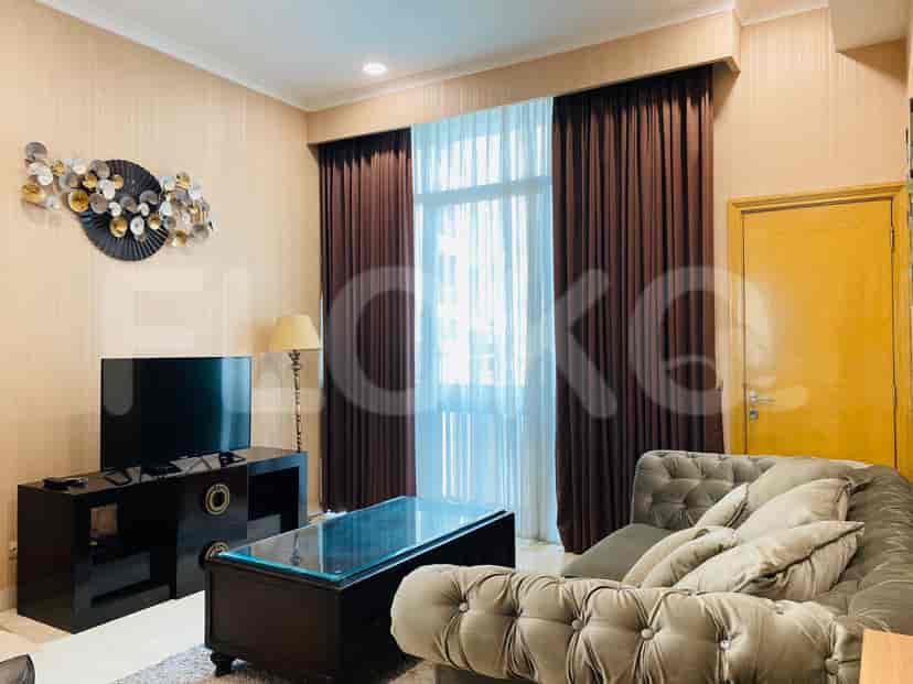 Another view of the living room with a TV, sofa and window.