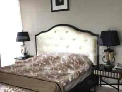 Bedroom with a queen-sized bed, bedside tables, and lamps.