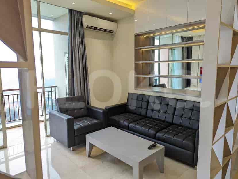 A living room showcasing a black leather sofa, chair, and a light-colored coffee table.