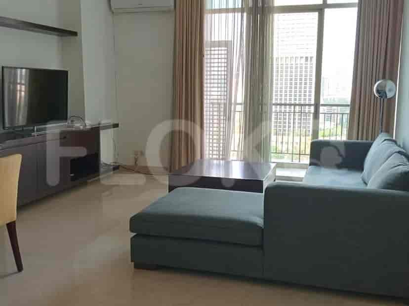A modern living room featuring an L-shaped grey sofa, a TV, and a dining area visible.