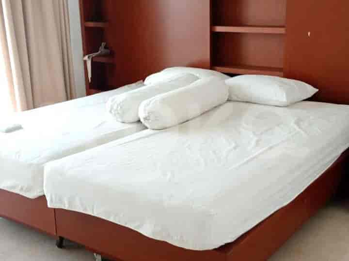 Bedroom with a double bed, a desk, and curtains.