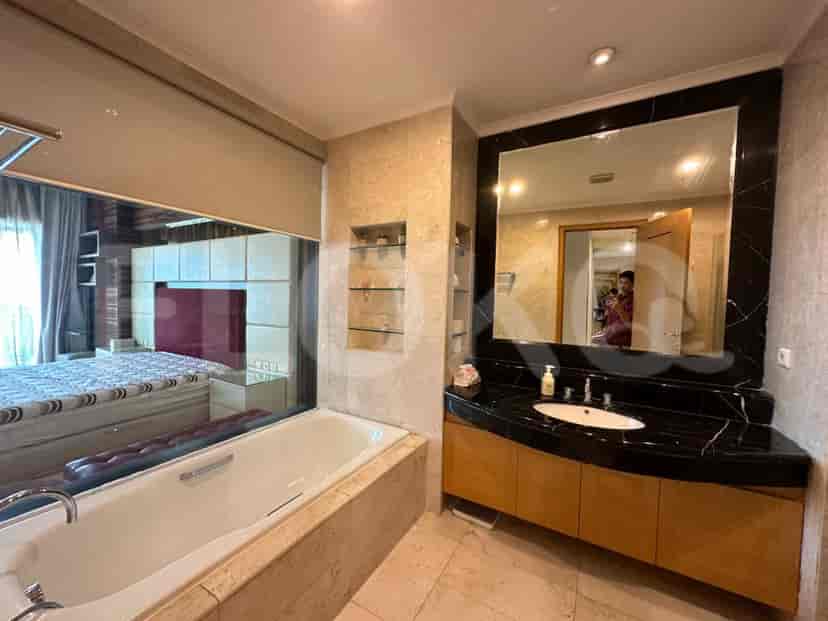 Kamar mandi mewah dengan bak mandi dan cermin besar.