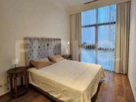 A cozy bedroom featuring a bed with a cushioned headboard and a nightstand.