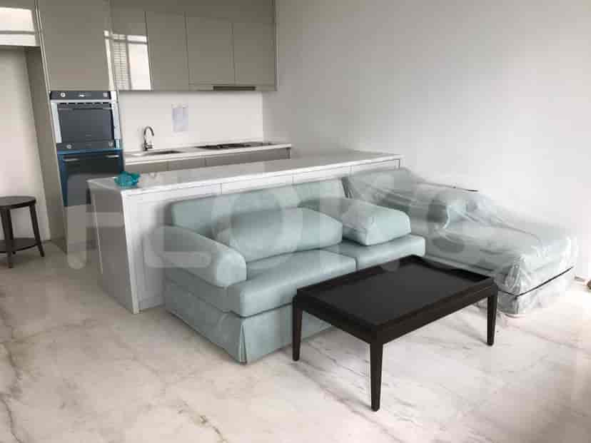 Open concept with blue sofa, kitchen island, and overhead cabinets.
