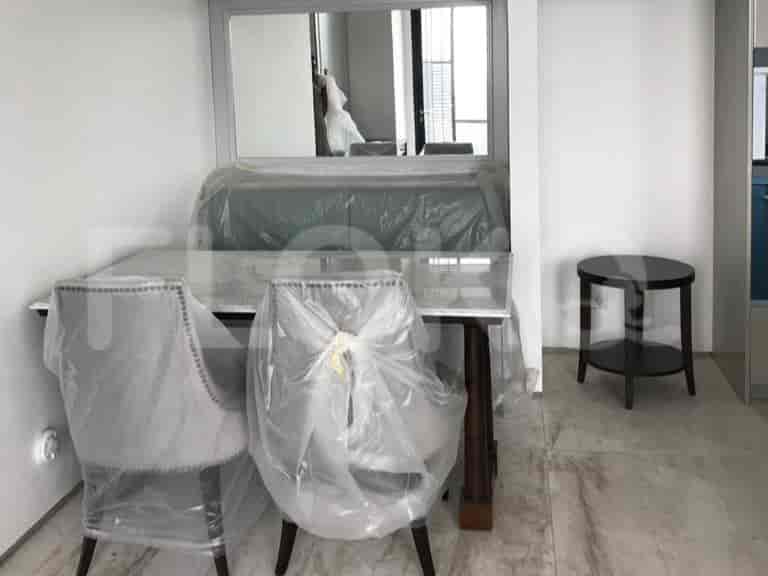 Dining area with a table, two chairs, and a mirror.