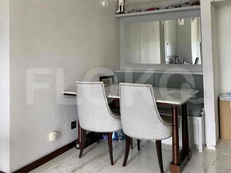 Dining area with a table, two chairs, and a mirror.