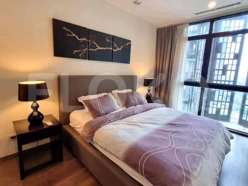 The bedroom features a bed, a bedside table and lamps.