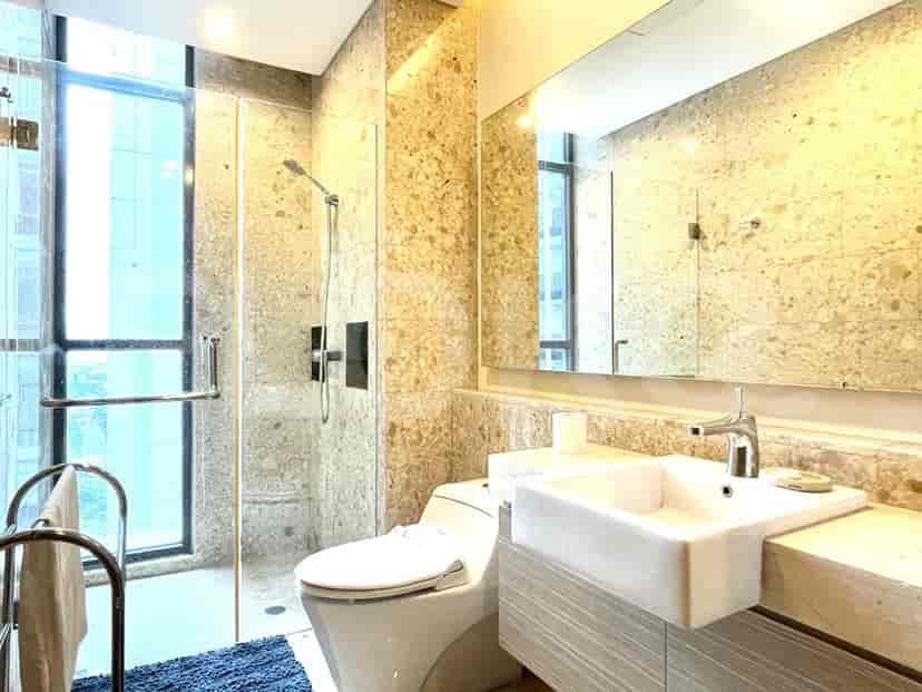A modern bathroom with a walk-in shower, toilet, and sink.