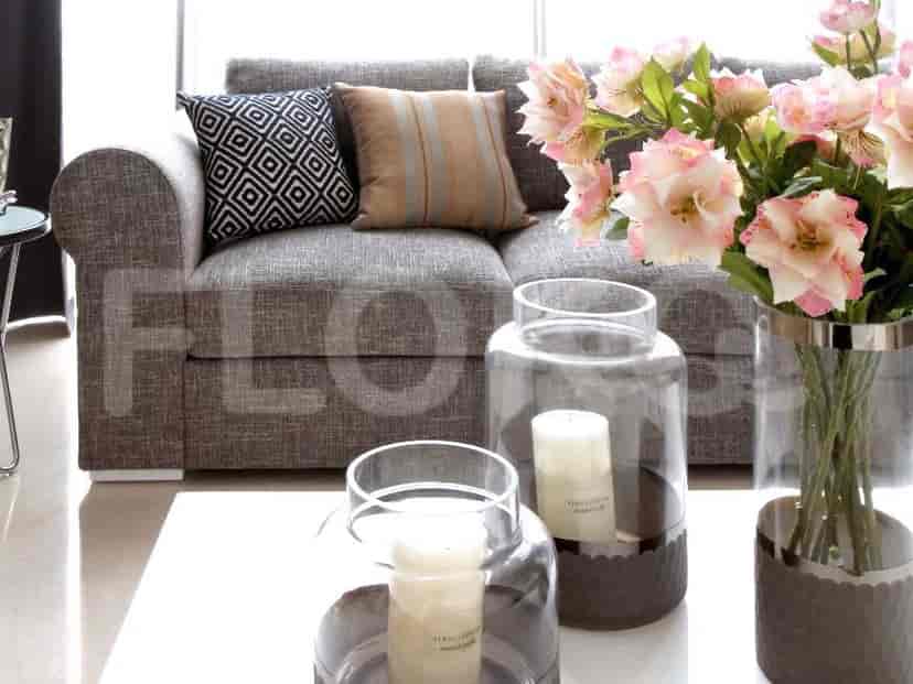 Living room with a grey sofa, coffee table, and decorative elements.