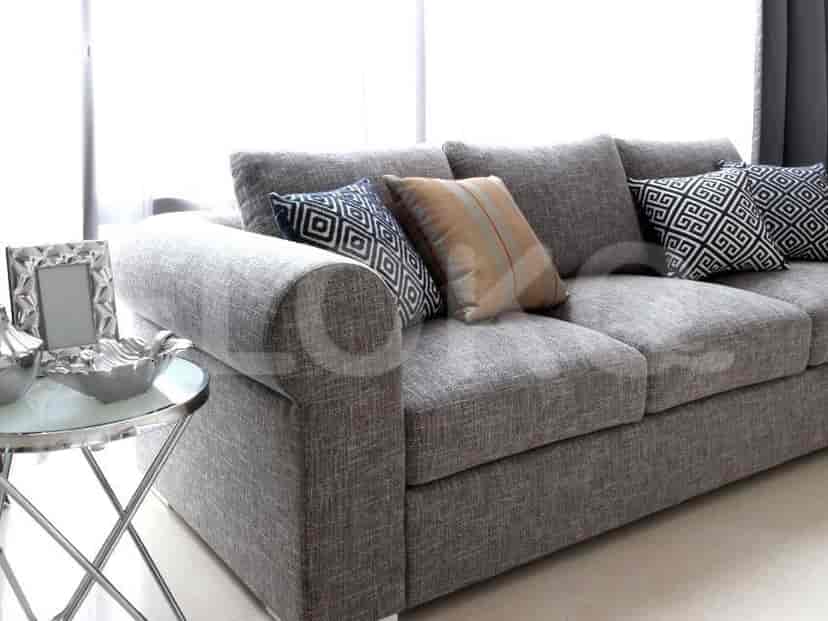 Close up of a section of the grey sofa and a side table with decor