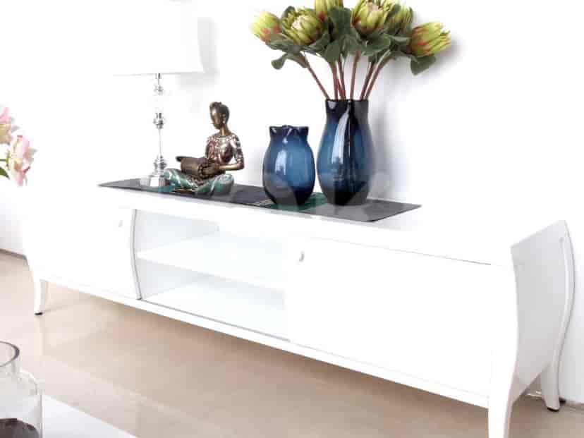 White media console with decorative items and a lamp.