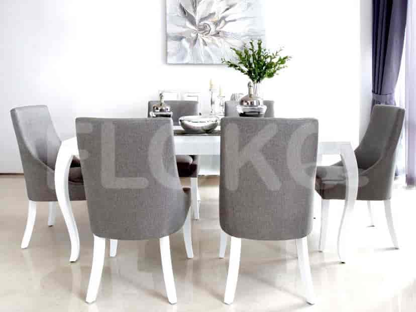 White dining table with grey chairs, featuring art and a neutral aesthetic.
