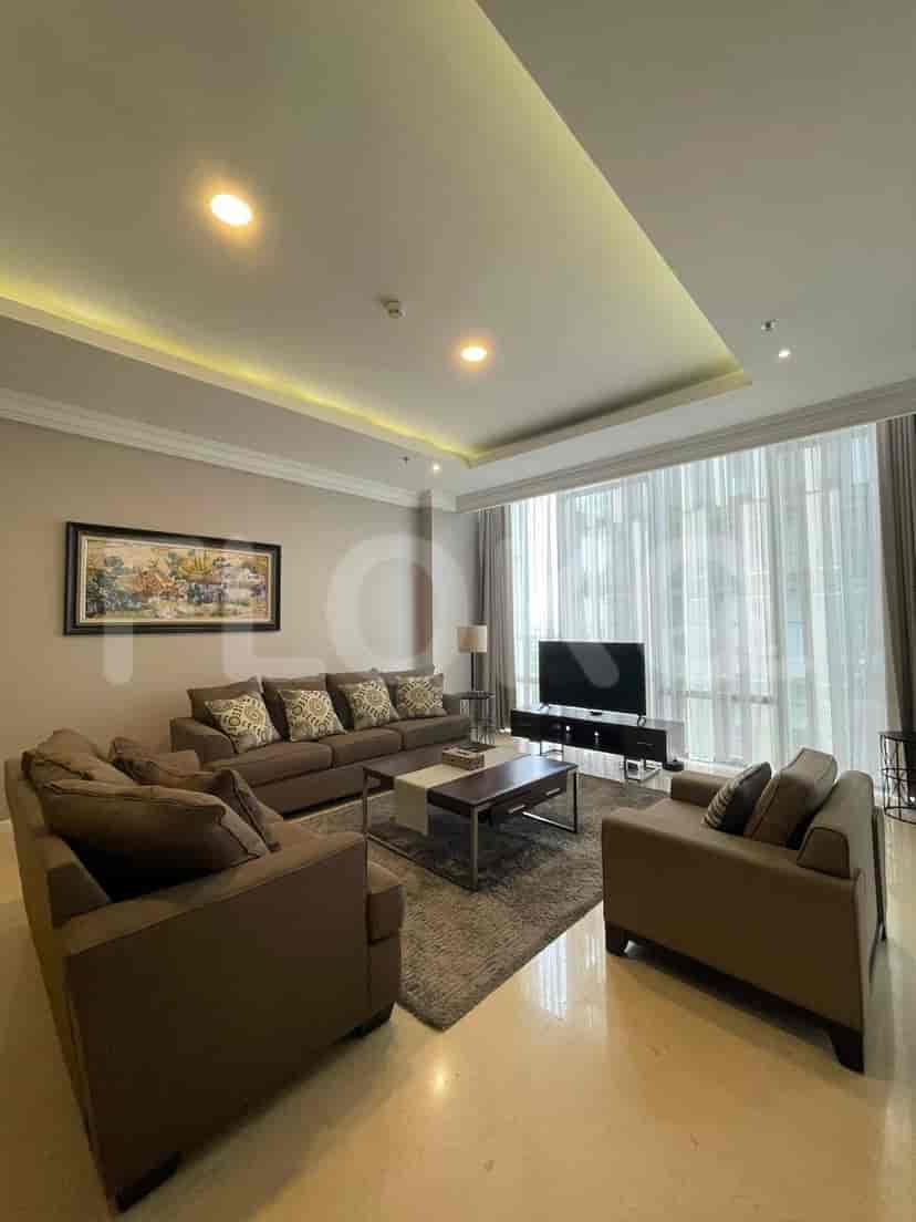 Modern living room featuring a grey L-shaped sofa, TV, and large windows.