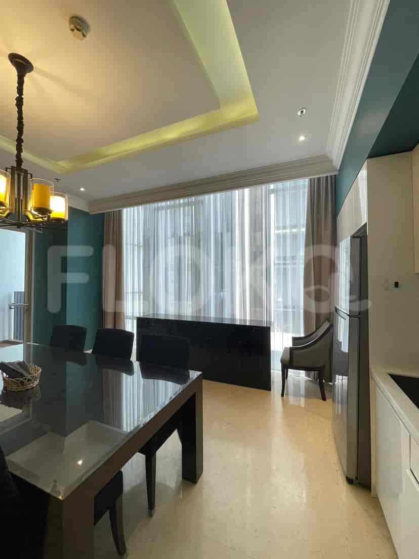 Dining area and kitchen with a glass table, chairs, and built-in cabinetry.