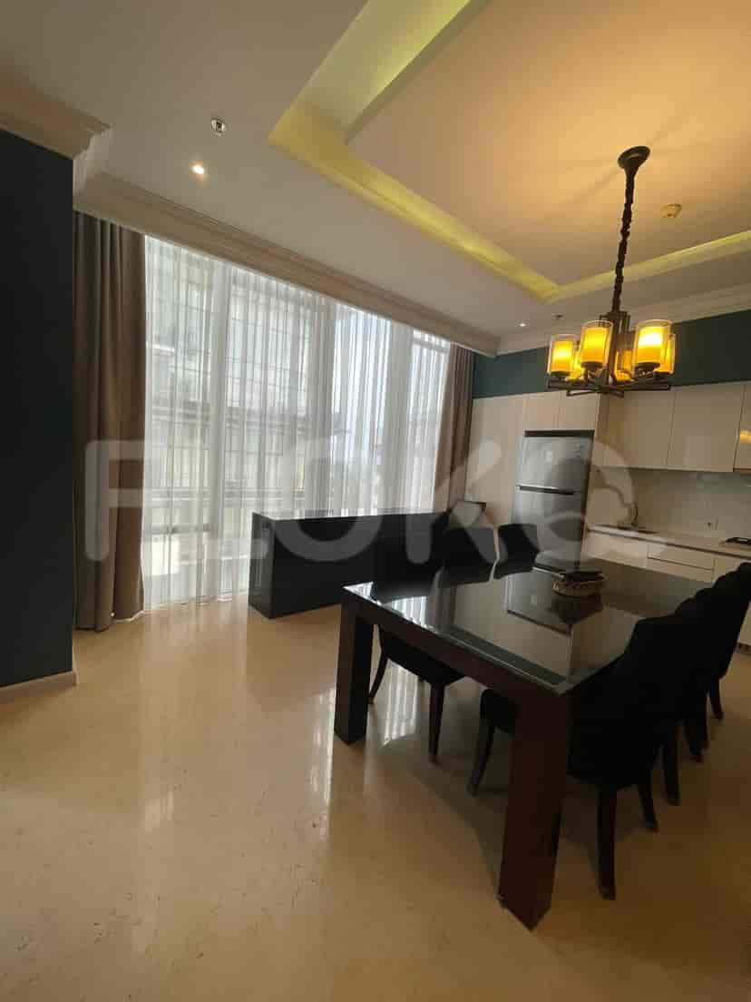 Dining area and kitchen with a glass table, chairs, and built-in cabinetry.