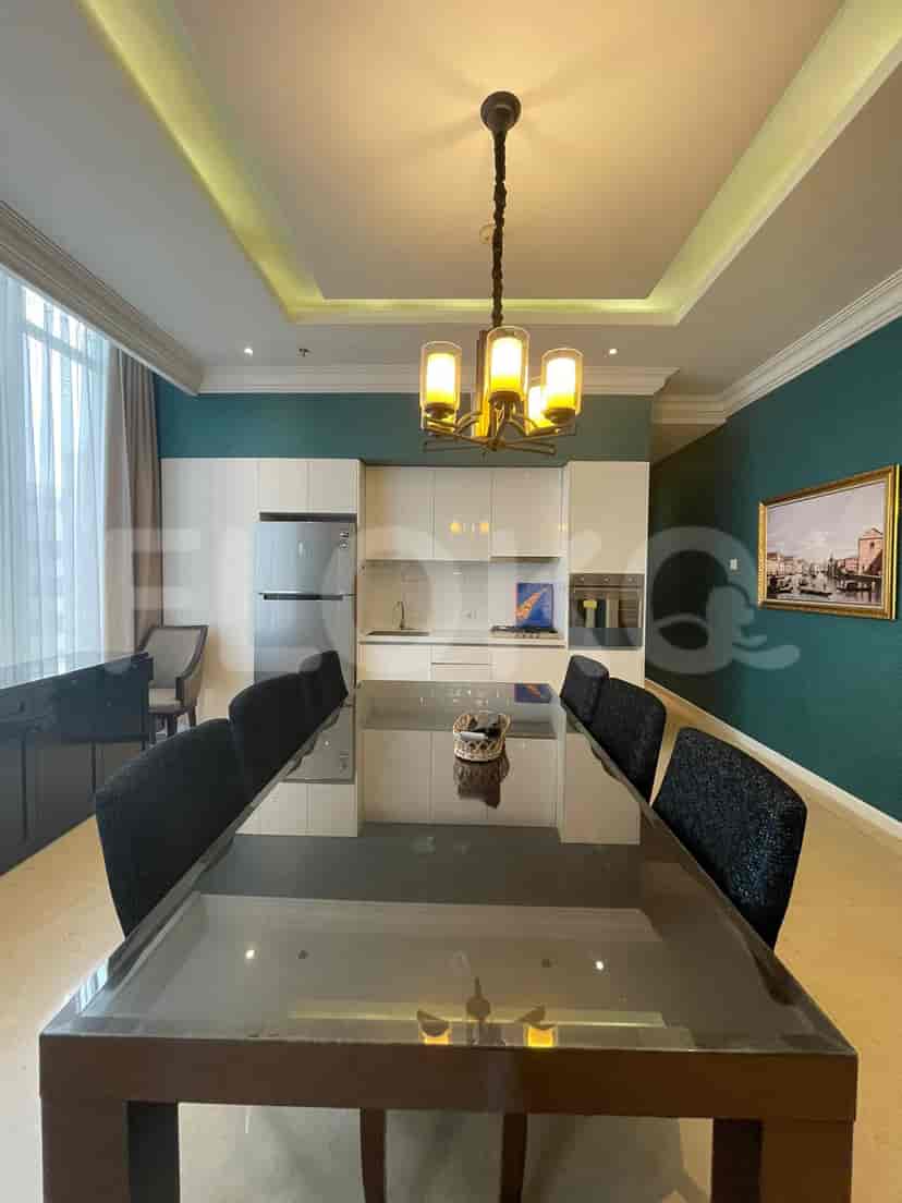 Dining area and kitchen with a glass table, chairs, and built-in cabinetry.