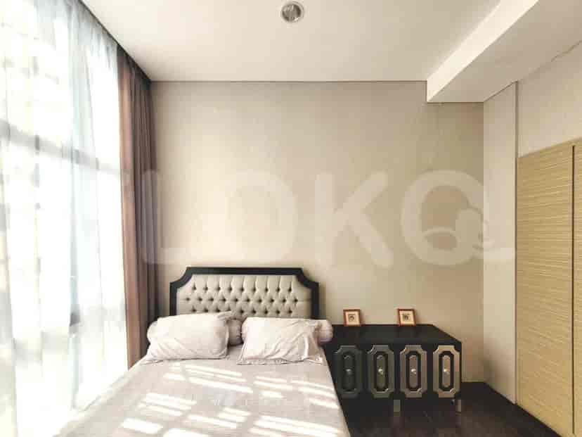 Kamar tidur dengan tempat tidur dan meja samping tempat tidur.