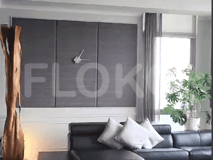 Living room with wooden sculpture, modern clock, and dark-colored paneling.