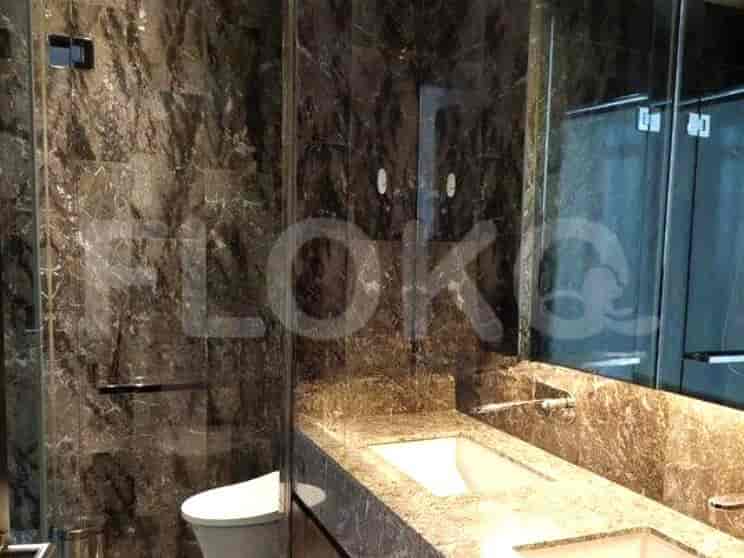 Luxurious bathroom with marble walls, a double vanity, and a toilet.