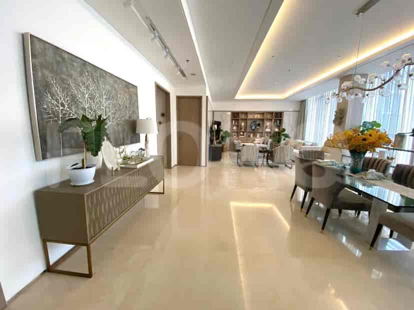 Elegant living room showcasing a built-in cabinet, dining area, and sophisticated decor.