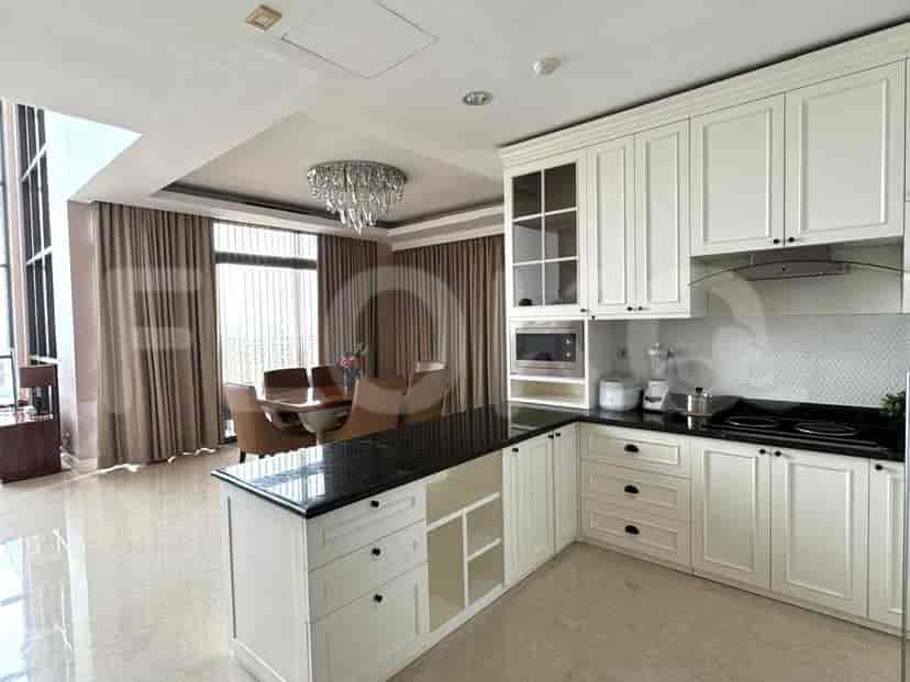 Open kitchen with white cabinetry, island, and a dining area with a chandelier.