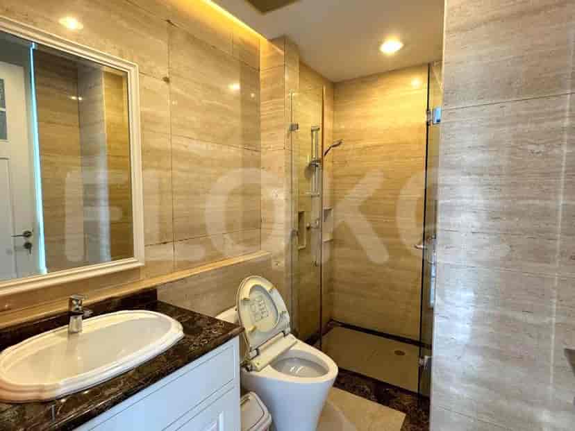 A second bathroom with marble finishes, a glass shower, and a toilet.
