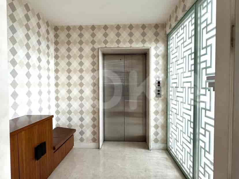 Hallway with an elevator and patterned wallpaper.
