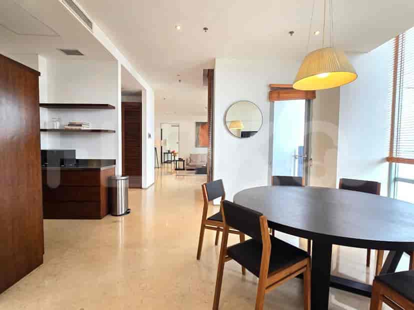A dining area with a round table, chairs, and a view into the living space.