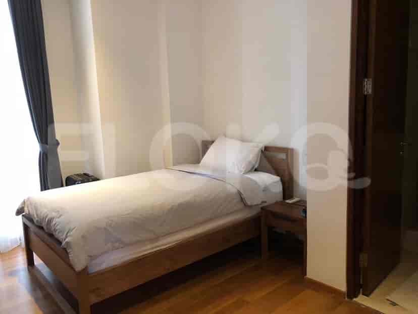 A minimalist bedroom with a single bed and wooden flooring.