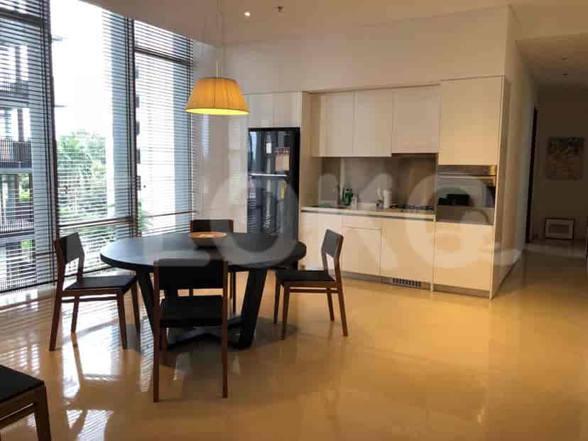 A dining room and kitchen with a modern design and wooden accents.