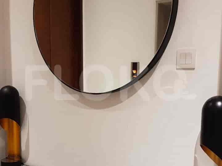A stylish entryway with a round mirror and modern lighting.
