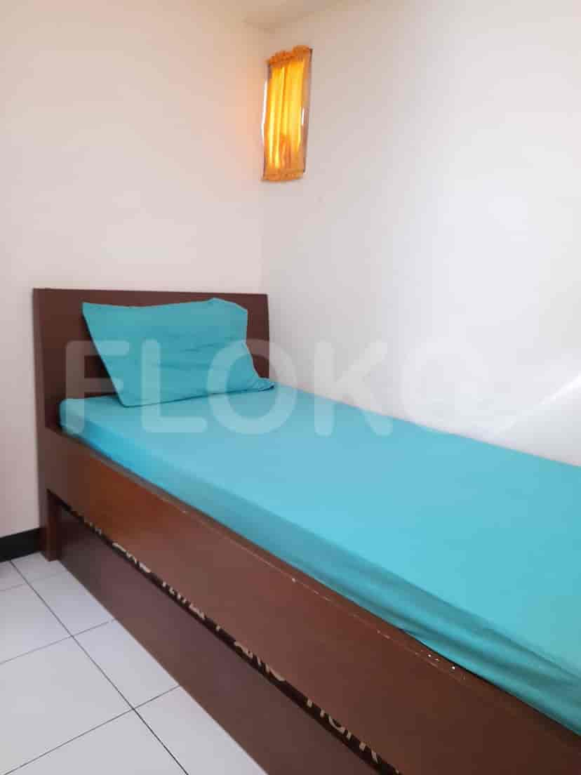 Kamar tidur dengan tempat tidur single dan perabotan sederhana.