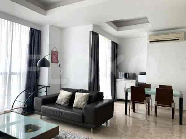 Bright living room with a dark leather sofa, glass coffee table, and marble floor.