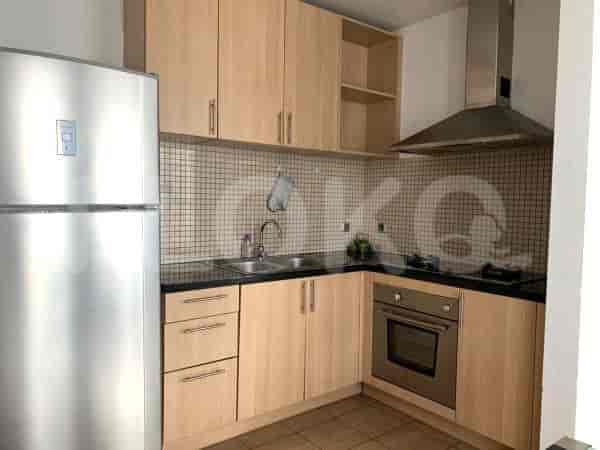 Modern kitchen with light wooden cabinets and stainless steel appliances.