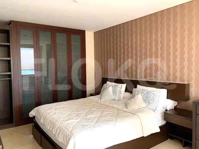 A spacious bedroom with a king-size bed, wardrobe, and bedside tables.