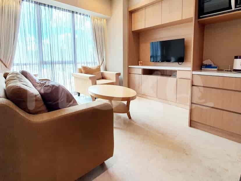A modern living room with a sofa, armchair, wooden coffee table, and entertainment unit.