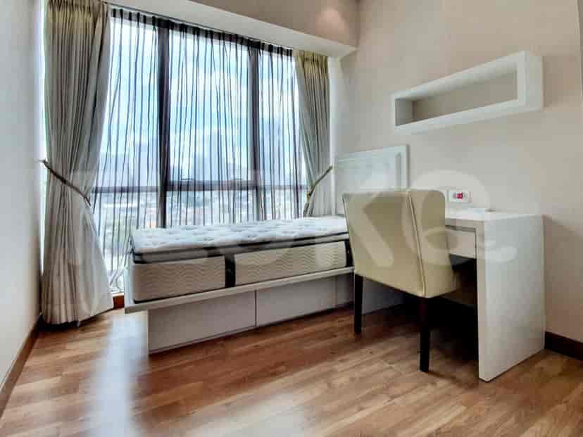 A bedroom with a single bed, study table, and large window.