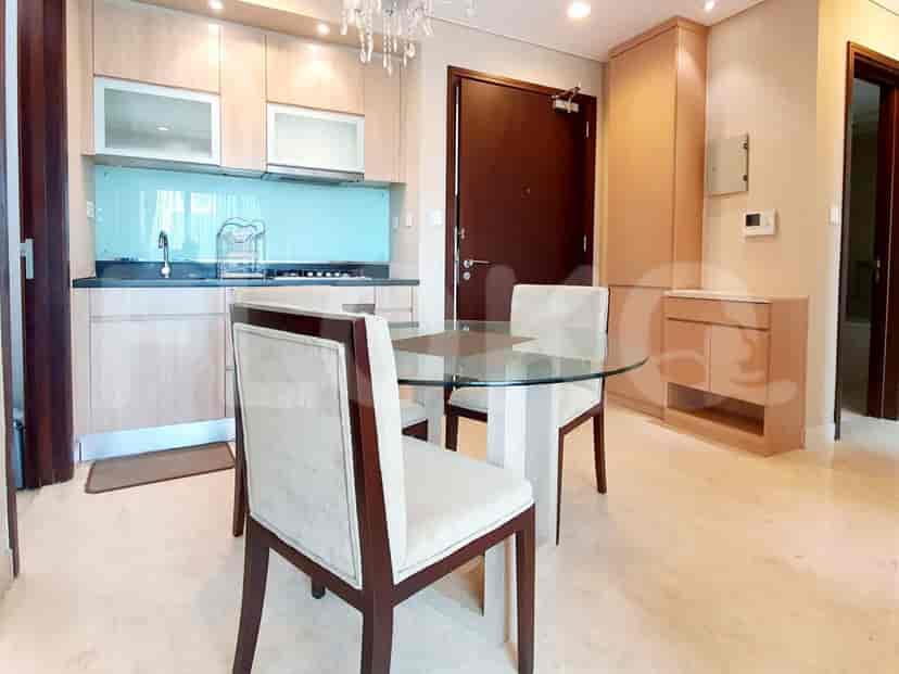 A kitchen and dining area with a glass dining table, modern cabinetry, and integrated appliances.